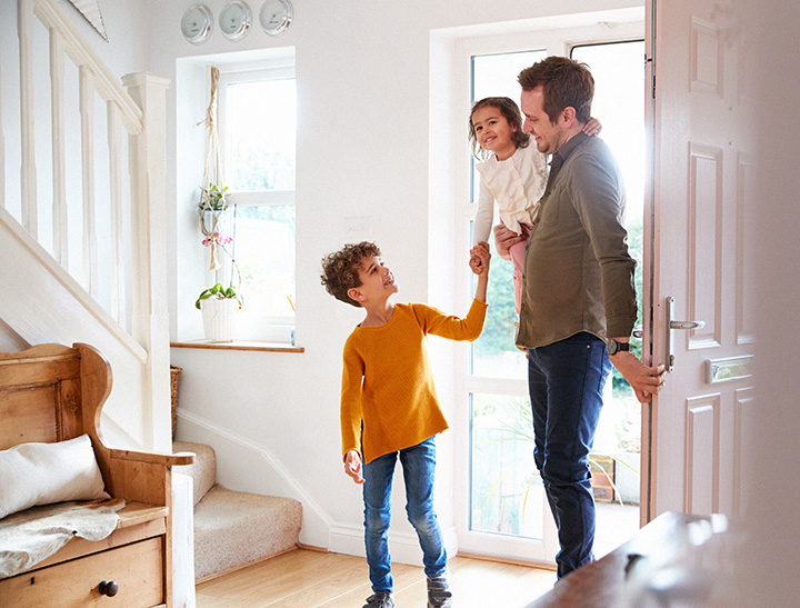 Image of a young family entering their new home.