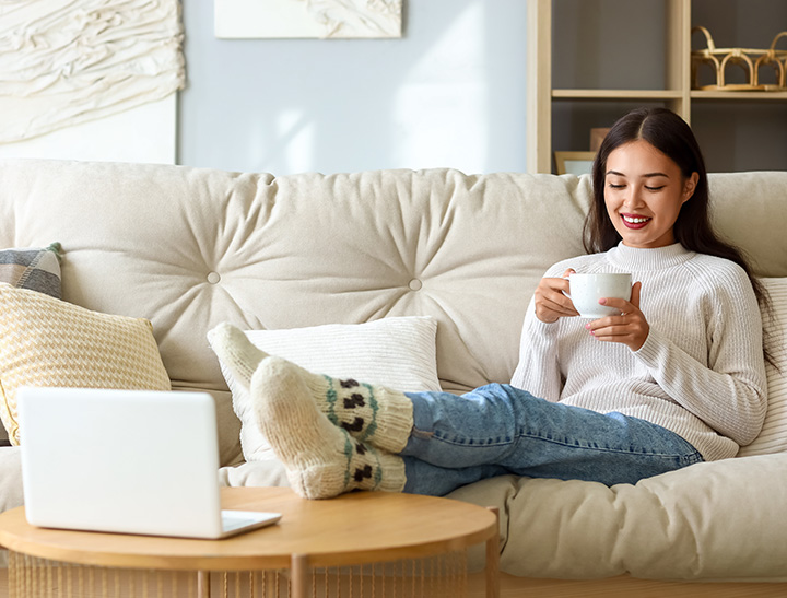 Image of young adult relaxing on sofa.