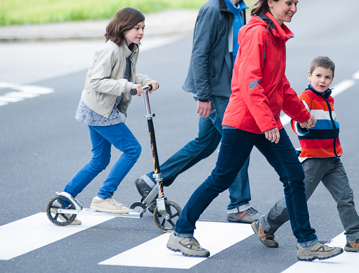 Image of young family using a pedestrian crossing.